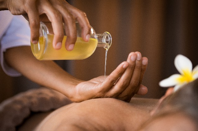 Therapist pouring massage oil at spa Jasa Pijat Panggilan Makassar 24 Jam Murah